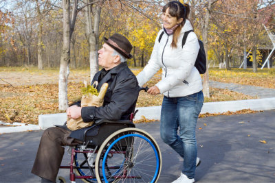 senior man on a wheelchair with his caregiver